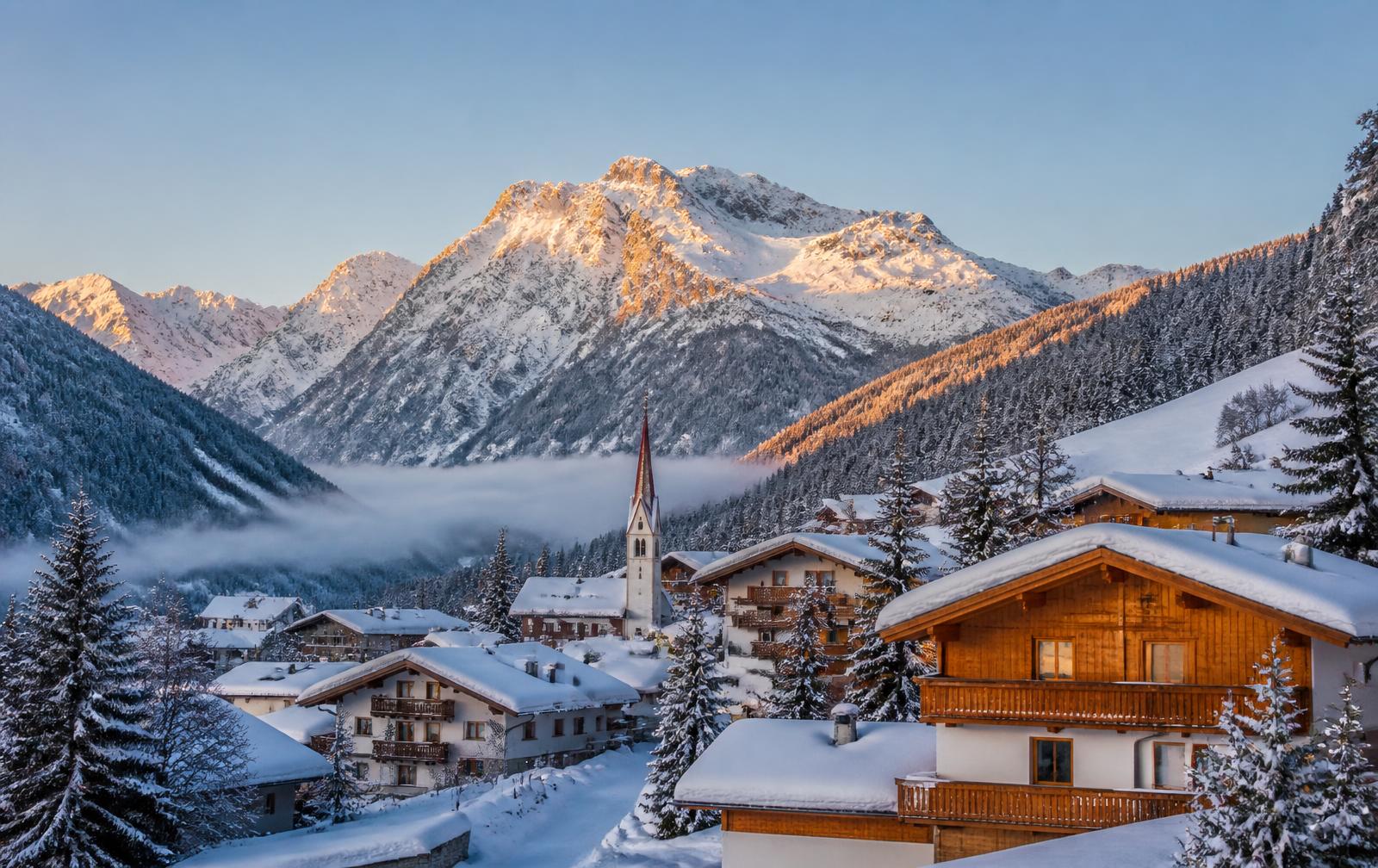 Verschneites Dorf und Berge in Sölden, Tirol