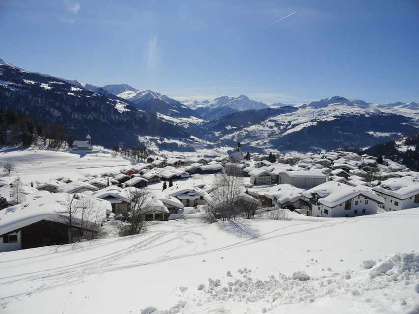 Snow-covered village of Falera with Alpine peaks behind