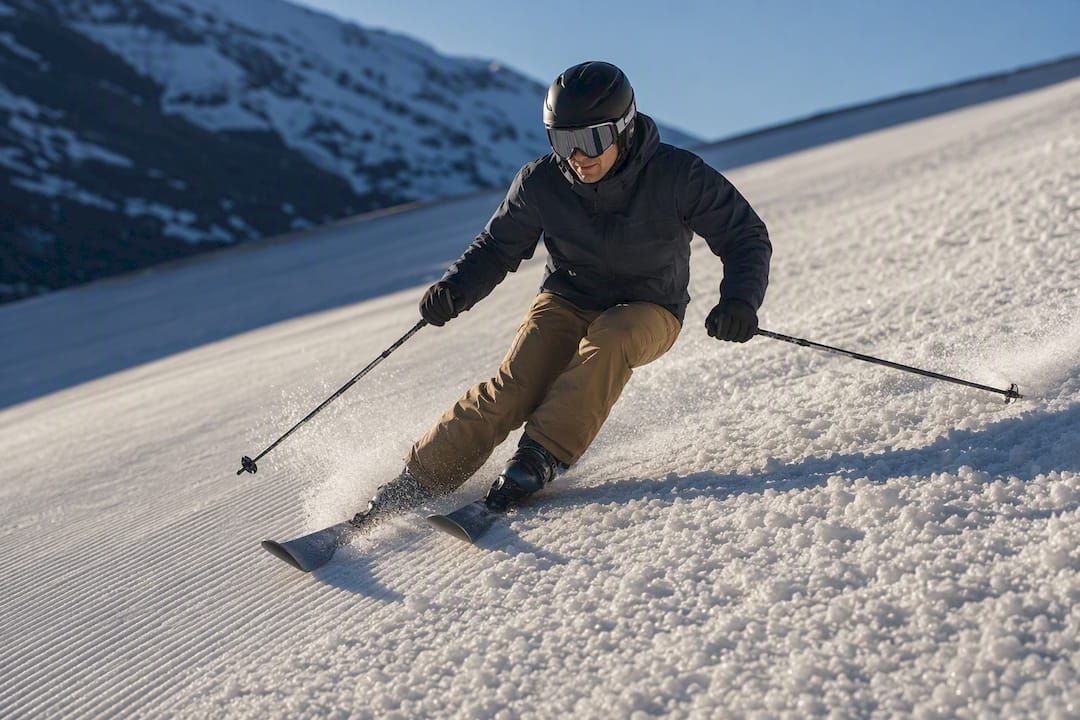 Skifahrer zieht eine Kurve durch weichen Frühlingsschnee