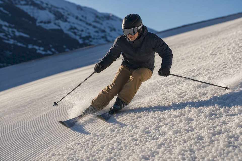 Skifahrer zieht eine Kurve durch weichen Frühlingsschnee