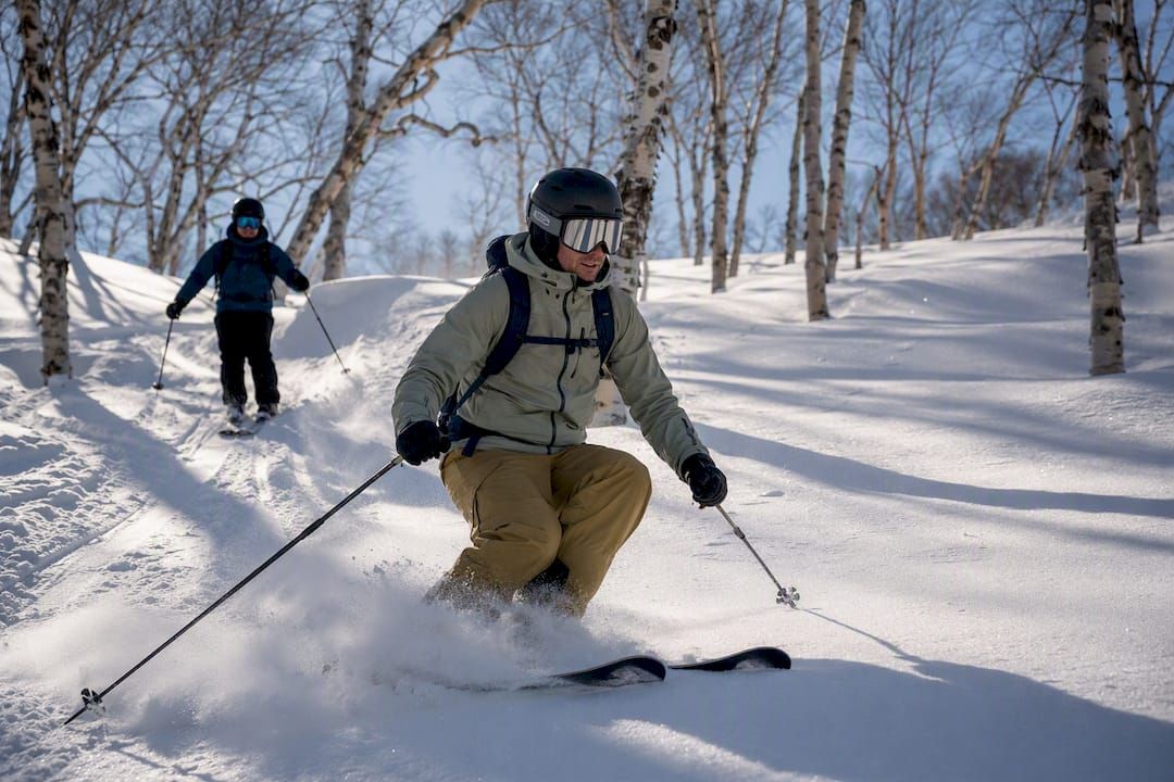 Fortgeschrittener Skifahrer bei einer geführten Abfahrt im Tiefschnee